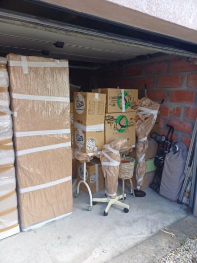 Déménagement avec des cartons et des meubles empilés dans un garage.